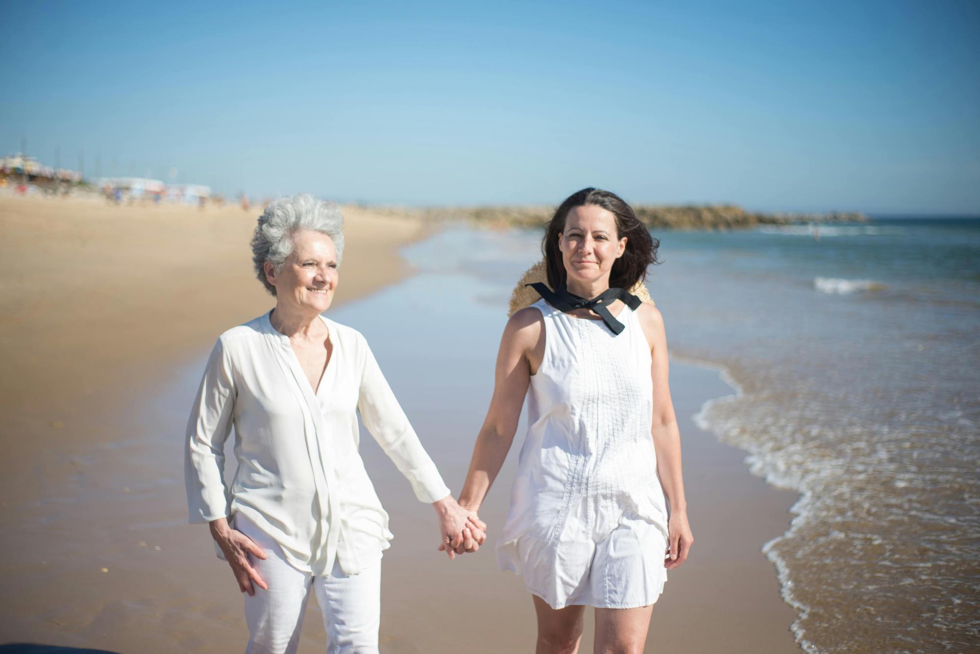 A mother holding her daughters hands on the beach A mother holding her daughters hands on the beach