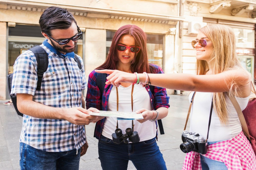 A group of tourist looking directions from their map